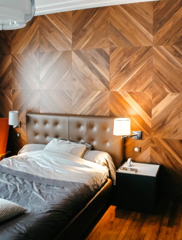 chambre avec revêtement mural en bois et tête de lit en cuir