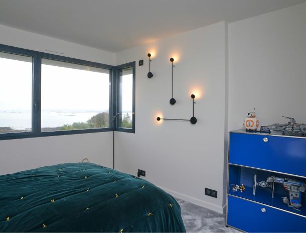 chambre avec luminaire mural design et meuble bleu roi