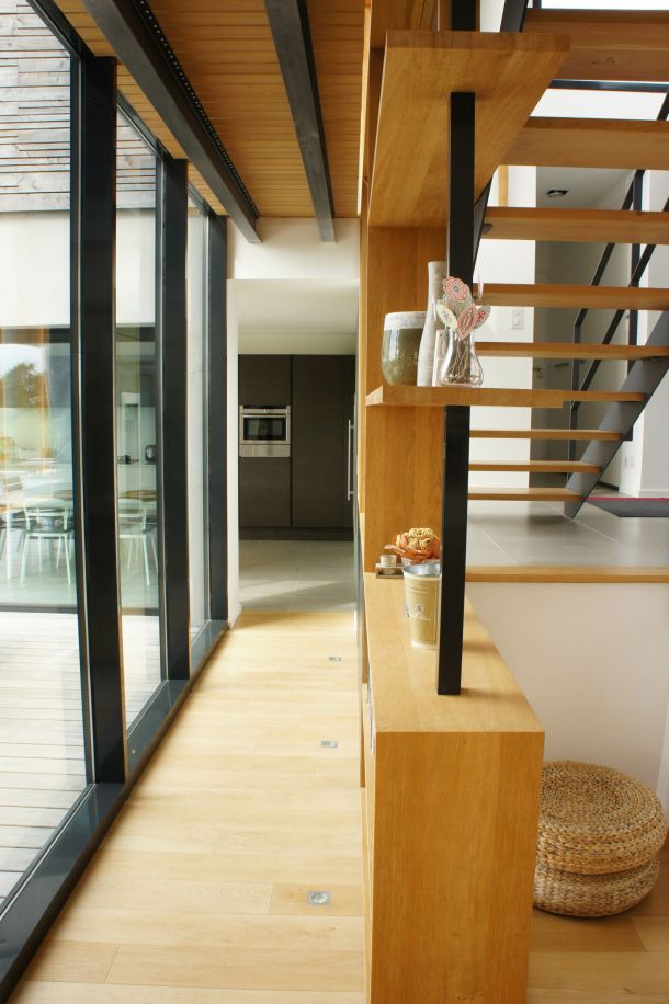 couloir avec des escaliers en bois et métal et baies vitrées